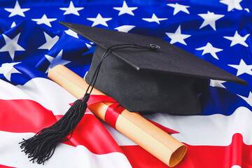 Graduation hat and diploma on USA flag