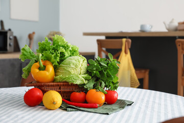 Basket with fresh vegetables on dining table in interior of modern kitchen