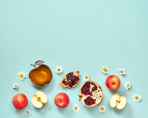 Rosh hashanah (jewish New Year holiday) concept. Traditional symbols. Apples, honey and pomegranates on a light blue background.