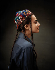 Art portrait of young beautiful girl with an embroidered hat on her head. Central Asian or oriental...