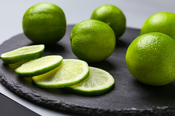 Fototapeta na wymiar Fresh green limes on slate plate