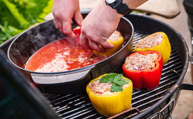 chef making stuffed pepper with tomato sauce