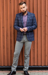 Man in gray jeans and a jacket posing
