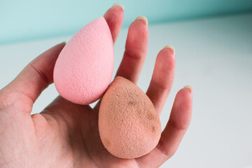 Pink beauty tear-shaped blender, dirty and clean egg-shaped sponges isolated on light background....