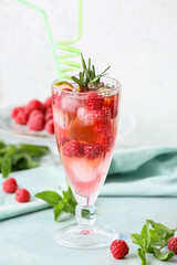 Glass of cold raspberry tea on table