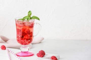 Cup of cold raspberry tea on table