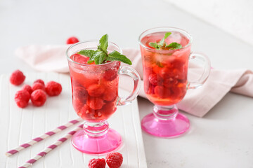Cups of cold raspberry tea on white background
