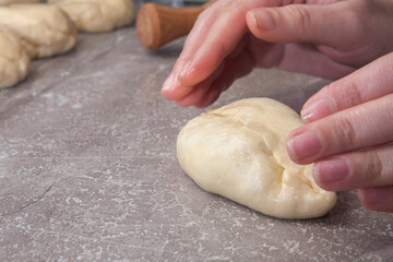 female hands make pies from dough