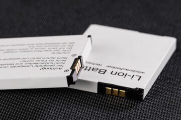 Zwei weiße Lithium-Akkus (Li-ion Battery / Akku) auf einem schwarzen Hintergrund