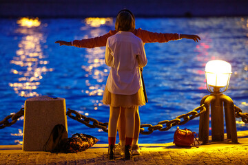 Two girls are resting on the embankment of the river