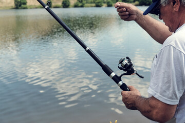 Fishing in river.A fisherman with a fishing rod on the river bank. Man fisherman catches a...