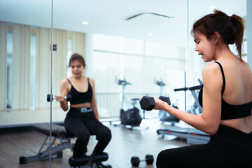 Fototapeta na wymiar young women workout lifting dumbbells in the fitness center