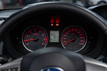 Car dashboard with red backlight: Odometer, speedometer, tachometer, fuel level, water temperature and more.
