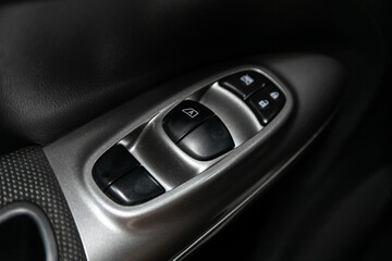 Interior of modern car. Side door buttons: window, mirror adjustment buttons, door lock. Car inside..