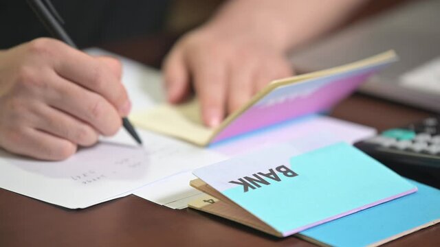 The hands of the men who are holding a bank passbook and weaving a budget.