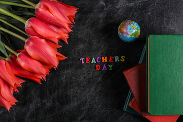 Teacher's Day or Knowledge Day. Red tulips, stack of books,  globe on chalk board. Top view. Back to school