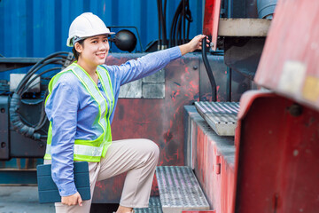 Asian young teen happy smile engineer worker working with heavy industry machine with safety suit and hardhat, looking camera.