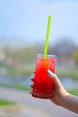 Hand holding smoothie shake cocktail. Drinking red healthy smoothie concept. Seasonal cocktail.