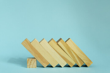 Wooden blocks on blue background. domino effect in business concept.