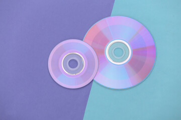 Compact disсs on purple blue pastel background. Top view