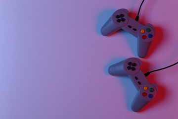 Retro gamepad in red blue gradient neon light. Gaming, video game competition. Top view