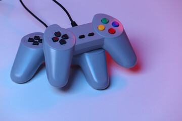 Retro gamepad in red blue gradient neon light. Gaming, video game competition.