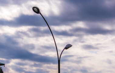 street lamp against cloudy sky