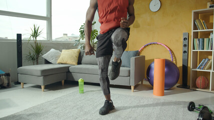 Fototapeta na wymiar Athletic strong young afro-american man doing warm-up exercises for full body stretching cardio before workout. Home isolation. Training people. Fitness concept.