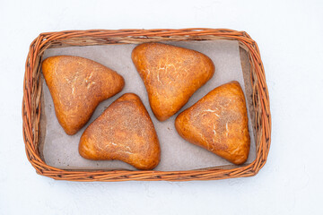 buns with apples and cinnamon in a basket on a white background