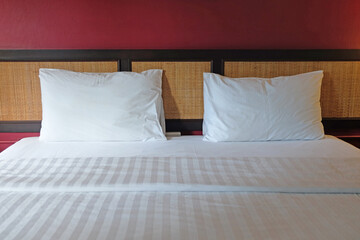 Front face view of a white bed set with red wall