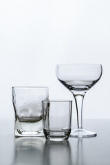Silueta de copas de vino y vaso de whisky sobre fondo blanco
