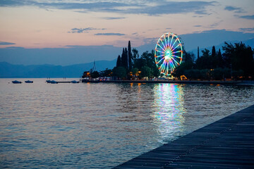 Ruota panoramica che riflette le luci sul mare