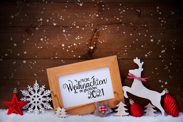 German Calligraphy Frohe Weihnachten Und Ein Glueckliches 2021 Mean Merry Christmas And Happy 2021. Red Christmas Ornament Like Tree, Ball And Wooden Deer. Wooden Background With Snow And Snowflakes