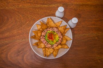 nachos tartar in the plate with avocado
