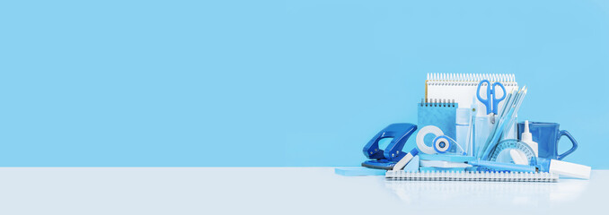 Group of various office supplies and school white and blue stationery on desk. Blue background monochrome. Banner for back to school or education and craft concept. Selective focus. Copy space