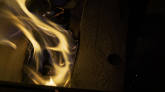 Flames burning fresh wood with embers glowing already, 4k