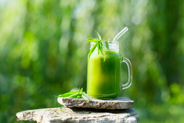 Healthy cannabis smoothie juice and hemp leaves outdoors. detox and healthy life. Copy spase. 
