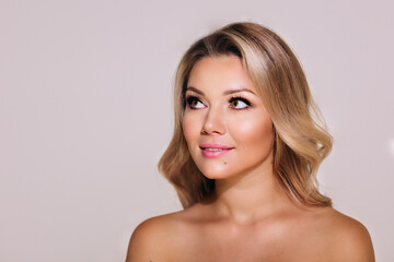 Fototapeta premium Wonderful woman looking up. Blond curly hair. Surprising facial emotions