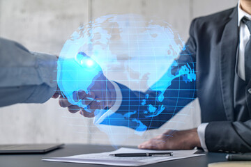 Double exposure of two businesspeople handshake and globe the earth hologram drawing background. Concept of international business. Formal wear.