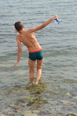 Caucasian child with brown hair outdoor on the beach in summer