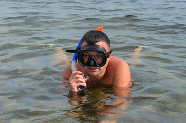 young caucasian man with brown hair outdoor with a mask and snorkel for swimming