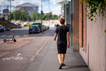 Fototapeta premium Man from behind walking on street