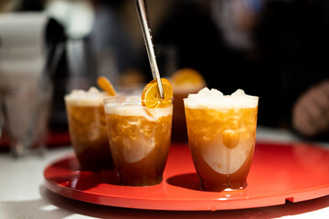 Barista preparando cocktails de caf&eacute; con adorno de naranja