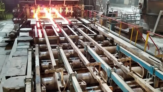 Red hot steel metal billets after molten steel casting. Continuous casting machine. Background of the blacksmith and metallurgical industry.