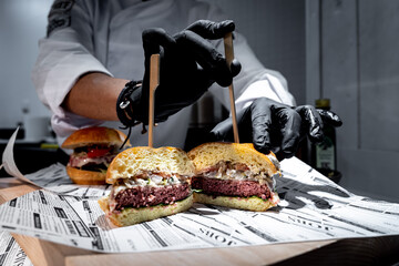 Manos de chef preparando sandwiches de hamburguesa