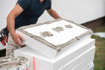 Repairman applying cement glue to a styrofoam board