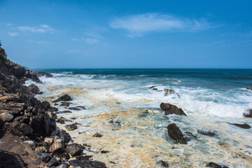 Fototapeta na wymiar The huge waves crashing into ston island against the blue sky and horizon at summer sea shore.