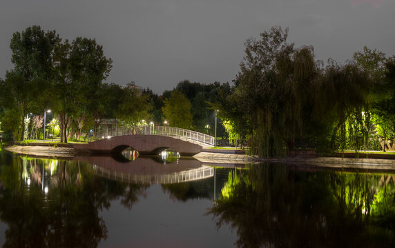 Night view of one of the illuminated bridges in Bordei Park in Bucharest. Romantic summer atmosphere.