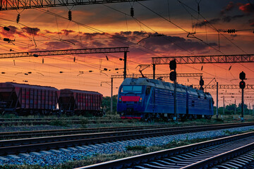 railway train and rail cars in a beautiful sunset, dramatic sky and sunlight