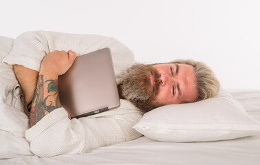 Sleep. Bearded man sleep with laptop. Work from home. Bearded man in bed. Morning and wake up. Man sleeping in comfortable bed at home. Man sleeping on white bed.